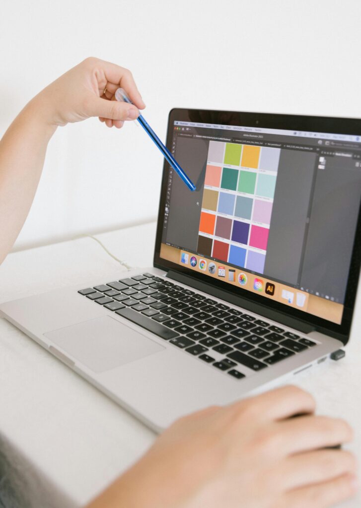 Close-up of hands using a laptop with a digital color palette, ideal for design work.